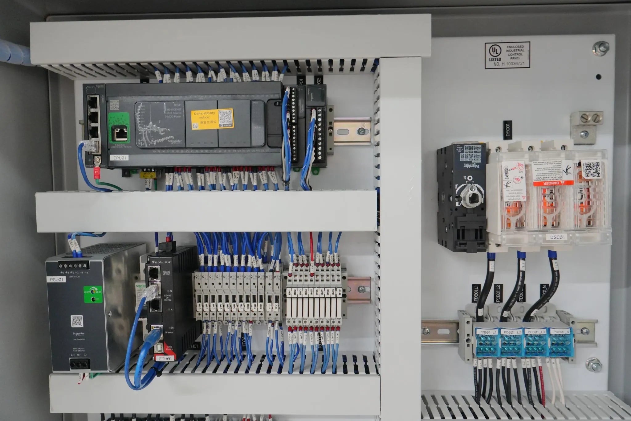 Open Panel Automation control panel with a PLC, labeled wiring, and a disconnect switch